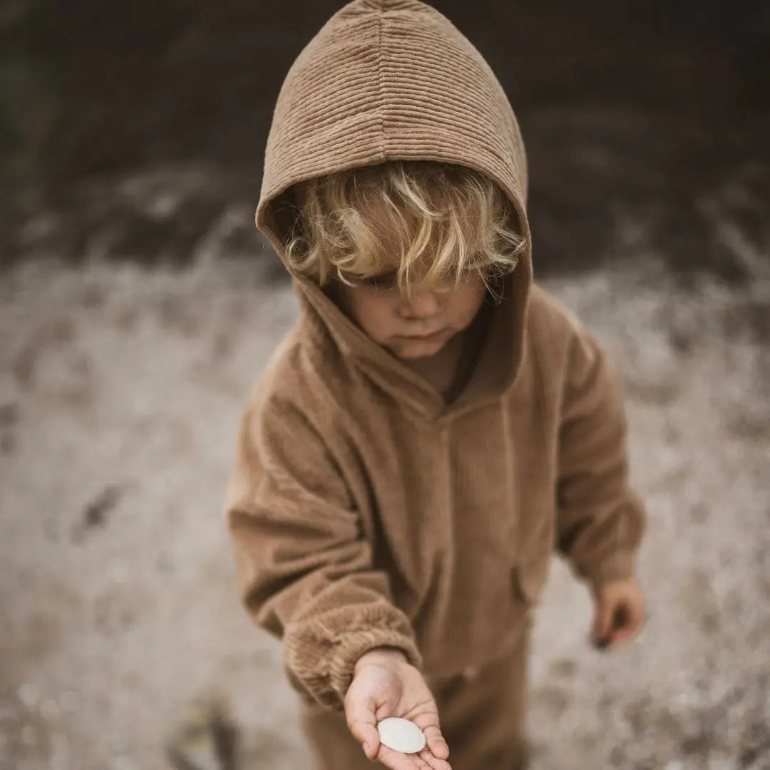 girl playing around wearing her Tan corduroy tracksuit which is has a corduroy hoodie and corduroy pants. Made from organic cotton, GOTS certified and sustainably made. front view 2