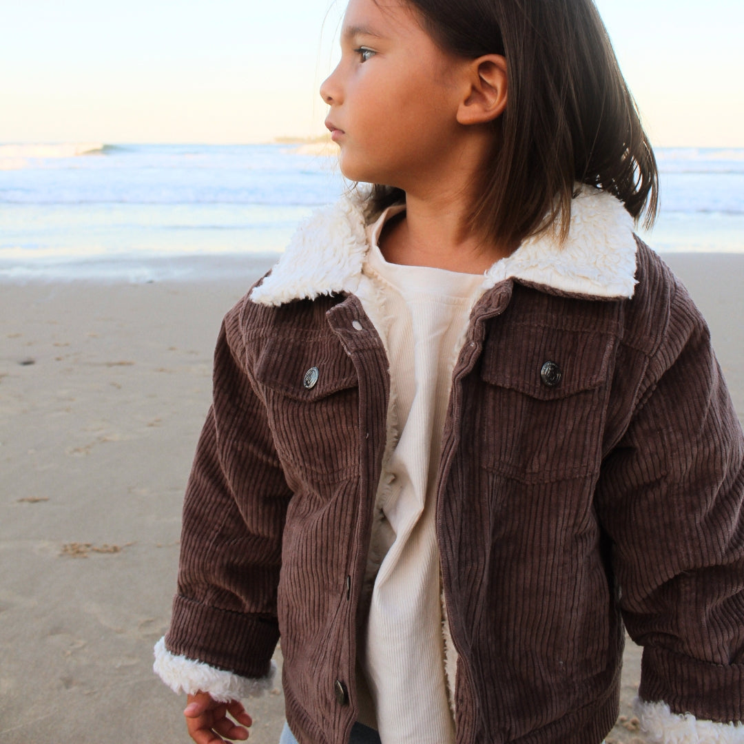 toddler wearing a corduroy jacket in Brown with sherpa fleece made from organic cotton close up