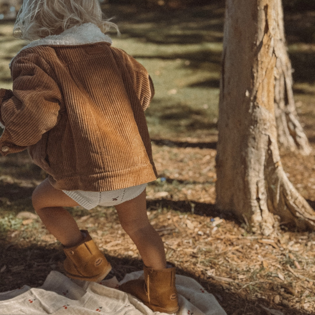 toddler wearing a corduroy jacket with sherpa fleece made from organic cotton back view