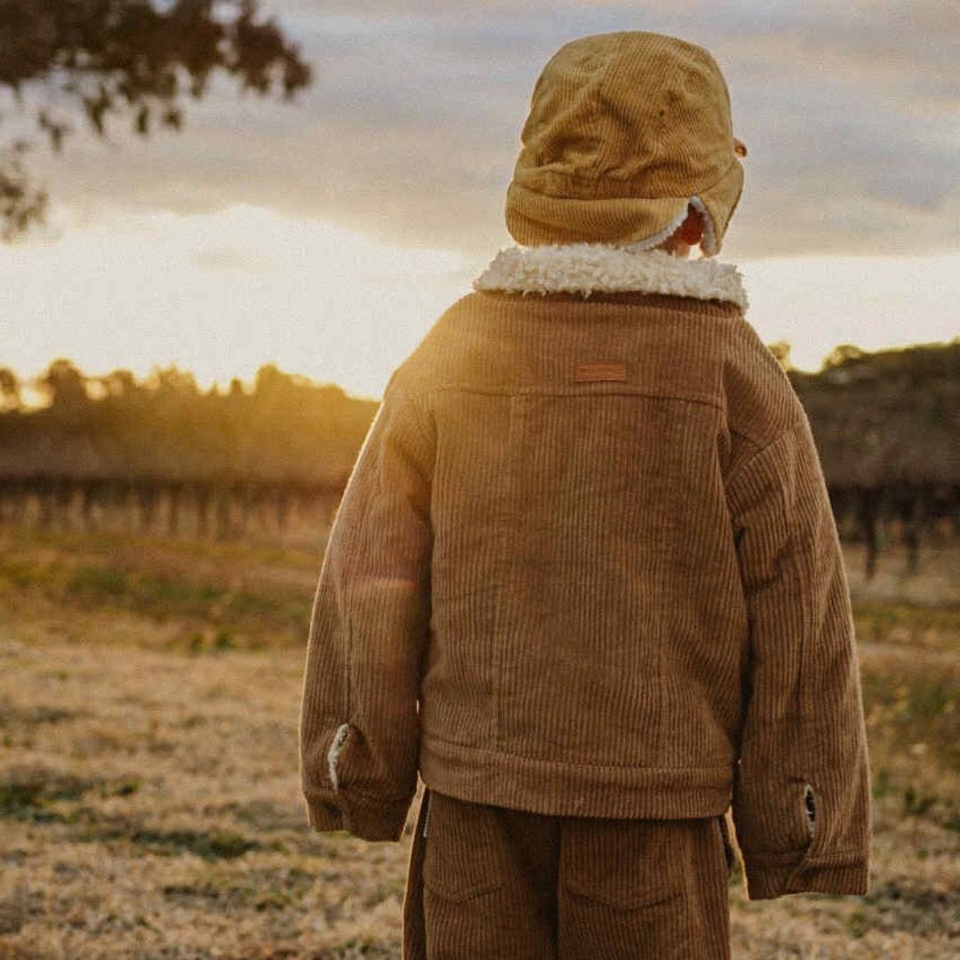 toddler wearing a corduroy jacket with sherpa fleece made from organic cotton back view 1