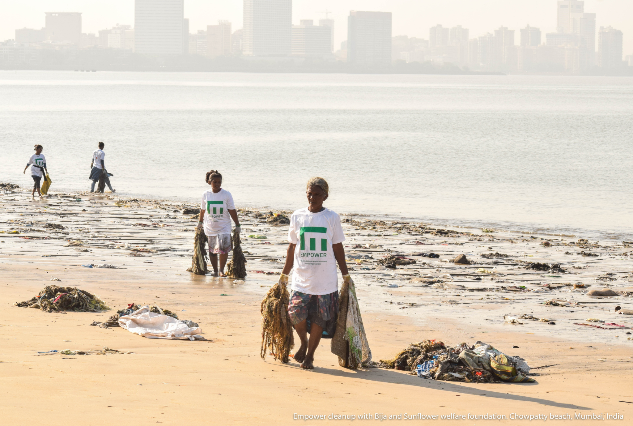 people cleaning up plastic waste on the beach which korduroy kidz supports