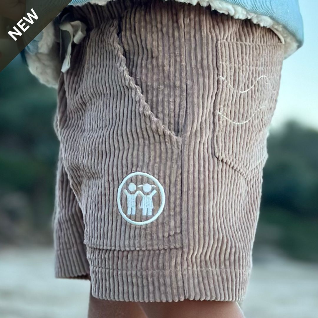 yung boy standing side on showing his Kids and toddlers tan corduroy shorts and a great shot of the korduroy kidz logo