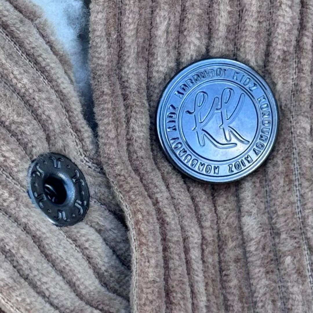 korduroy kidz button close up on a tan sherpa fleece corduroy jacket