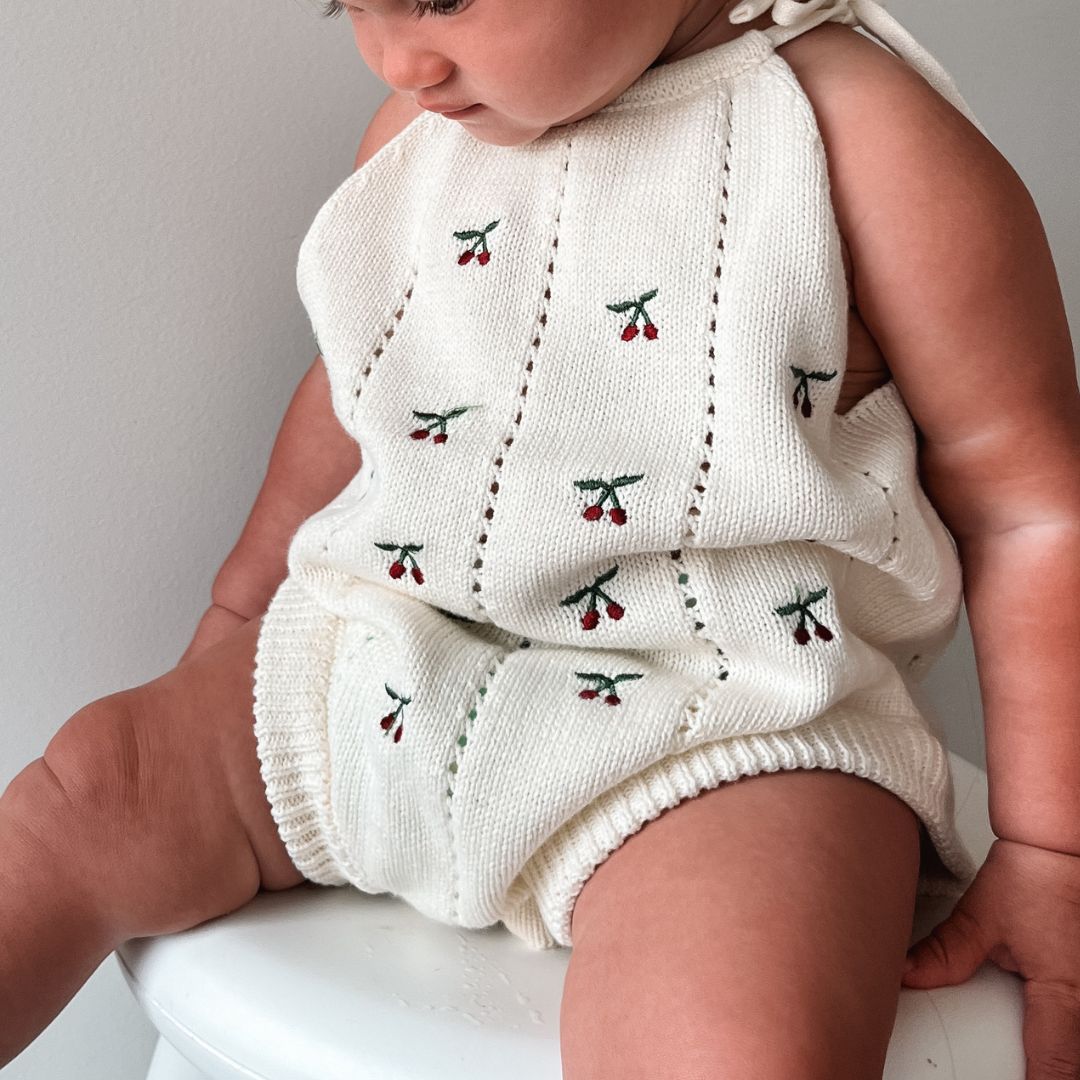 organic cotton romper for babies ages 0 - 24 months. Croquet style romper in beige with Cherry embroided into it front view