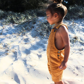 organic cotton corduroy overalls in orange for kids and toddlers. full garment side on