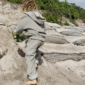 boy wearing his Kids and toddlers sage corduroy tracksuit with corduroy pants and hoodie climbing a rock