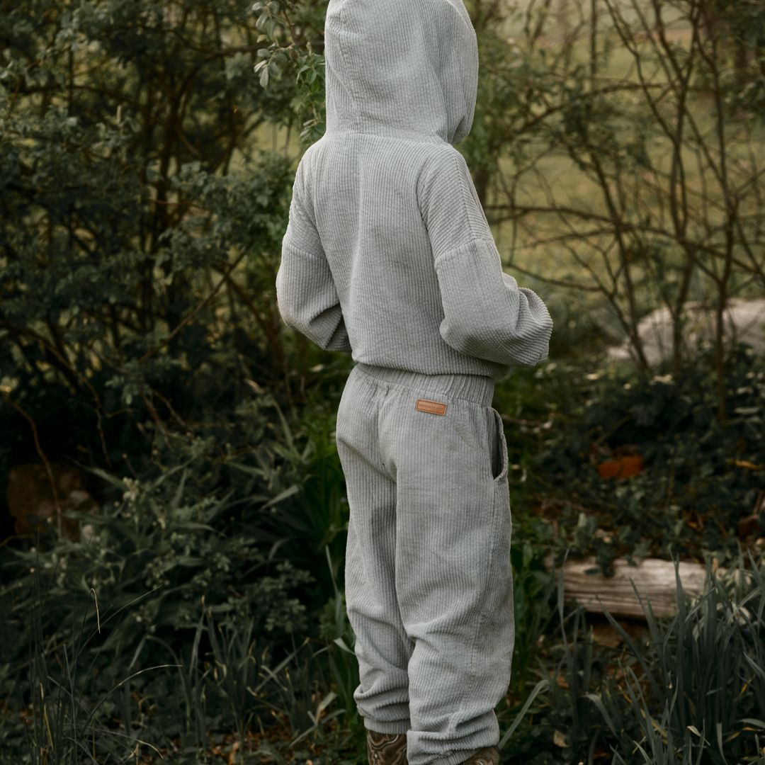 a boy in his Kids and toddlers sage corduroy tracksuit with corduroy pants and corduroy hoodie in GOTS Certified cotton corduroy