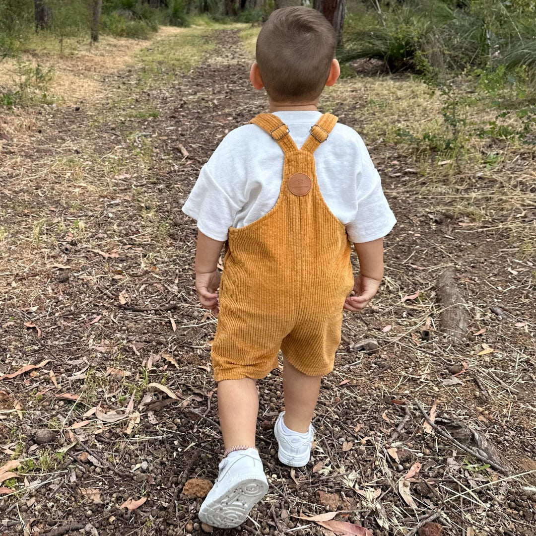 short leg overall, dungaree in colour orange made from organic cotton corduroy clothing for infants, toddlers and kids