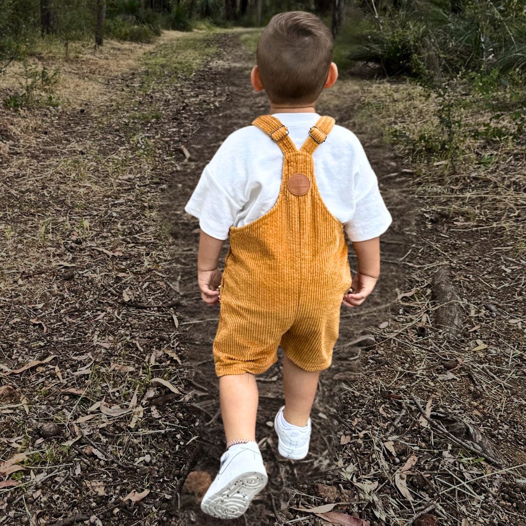 short leg overall, dungaree in colour orange made from organic cotton corduroy clothing for infants, toddlers and kids