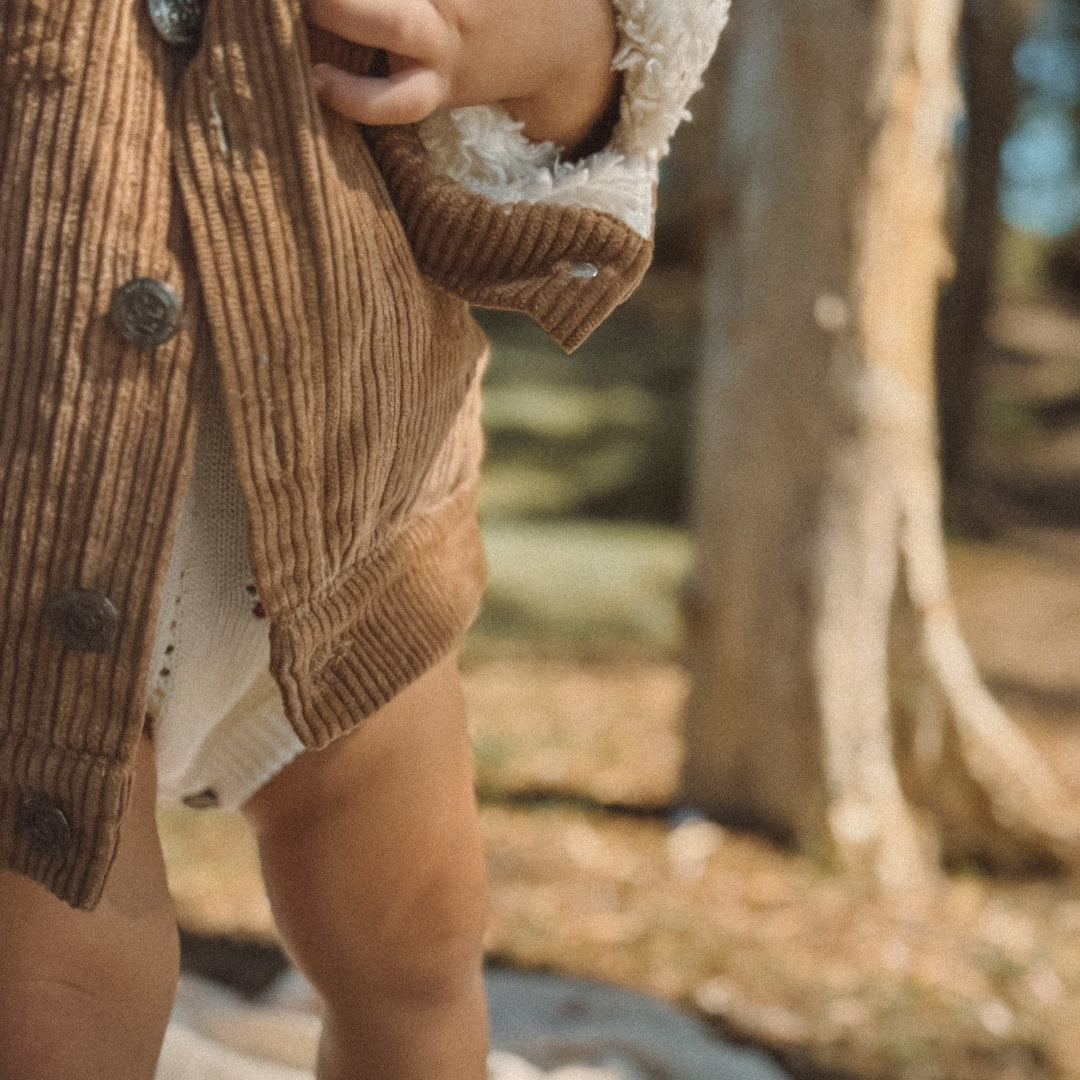 toddler wearing a corduroy jacket with sherpa fleece made from organic cotton close up buttons